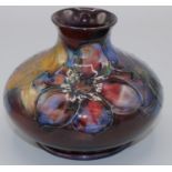 Moorcroft Pottery: Flambe Clematis pattern squat vase, tube lined with purple and red flowers on