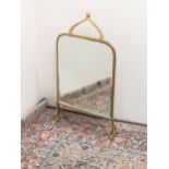 Art Nouveau brass framed mirrored fire screen, with scrolled handle, and bevel plate on outsplayed