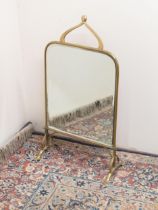 Art Nouveau brass framed mirrored fire screen, with scrolled handle, and bevel plate on outsplayed