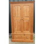 Modern pine wardrobe, moulded cornice above two twin panel doors above a drawer with turned wooden
