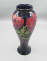 Moorcroft Pottery: Anemone pattern tall baluster vase, tube lined with red and purple flowers on