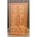 Modern pine wardrobe, moulded cornice above two twin panel doors above a drawer with turned wooden