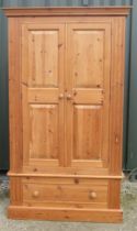 Modern pine wardrobe, moulded cornice above two twin panel doors above a drawer with turned wooden