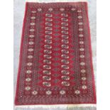 Bokhara pattern red ground wool rug, field with octagonal medallions, in hooked stylized striped