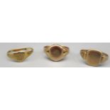9ct yellow gold signet ring, the oval face engraved EW, size K, and two other signet rings, all