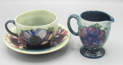 Moorcroft Pottery: Anemone pattern cup, saucer and jug, tube lined with red/purple flowers on