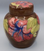 Moorcroft Pottery: Hibiscus pattern ginger jar and cover, tube lined with red and blue flowers on