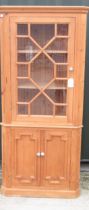 George III style pine standing corner cabinet, with moulded cornice and glazed door above a