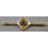 15ct yellow gold bar brooch set with central amethyst and seed pearls in floral mounts, stamped