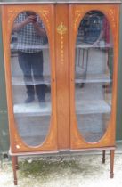 Edwardian inlaid mahogany and boxwood strung display cabinet, with two oval glazed doors and three