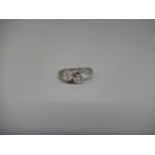 18ct white gold crossover ring set with two round cut diamonds in claw settings, on plain shank,