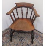 Early C20th smokers bow armchair with stepped back and shaped elm seat on turned supports joined