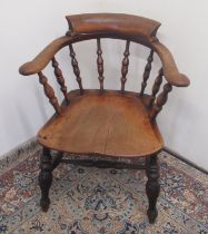 Early C20th smokers bow armchair with stepped back and shaped elm seat on turned supports joined