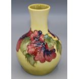 Moorcroft Pottery: Hibiscus pattern baluster vase, tube lined with pink and purple flowers on yellow