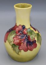 Moorcroft Pottery: Hibiscus pattern baluster vase, tube lined with pink and purple flowers on yellow