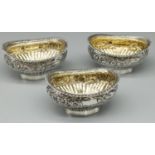 Set of three Victorian hallmarked silver oval salts, part lobed with floral band, gadrooned rim