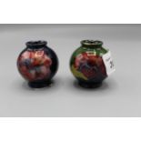 Moorcroft Pottery: two Hibiscus pattern miniature vases, tube lined with purple and yellow flowers