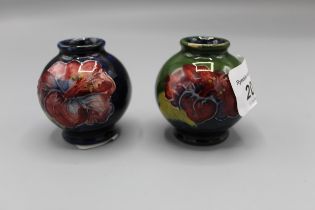 Moorcroft Pottery: two Hibiscus pattern miniature vases, tube lined with purple and yellow flowers