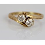 18ct yellow gold diamond set crossover ring, the round cut diamonds set in claw settings, on grooved