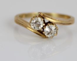 18ct yellow gold diamond set crossover ring, the round cut diamonds set in claw settings, on grooved