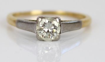 18ct yellow and white gold solitaire ring, the round cut diamond in white gold claw setting, on