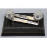 George V rectangular inkstand with two hallmarked silver pipe ink wells, on ebonised wooden base,