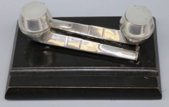 George V rectangular inkstand with two hallmarked silver pipe ink wells, on ebonised wooden base,