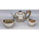 George V hallmarked silver three piece tea service, with part lobed oval bodies, teapot with