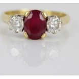 18ct yellow gold ruby and diamond ring, the central oval cut ruby flanked by two round cut diamonds,