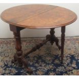 Victorian figured walnut Sutherland table, two fall leaves on fluted baluster supports and scroll