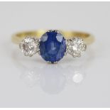 18ct yellow gold sapphire and diamond three stone ring, the central oval cut sapphire flanked by two