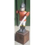 Folk Art style Soldier Whirlygig, painted with red jacket and black helmet, on oak base, H86cm
