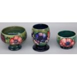 Moorcroft Pottery: three Anemone pattern vases, tubelined decoration of purple and pink flowers on