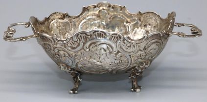 Late C19th Continental silver two handled oval bon bon dish, repousse with scrolls and buildings, on