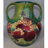 Moorcroft Pottery: Finches pattern twin handled vase, tubelined decoration of birds and fruit on a
