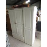 White painted pine three door wardrobe with fitted interior and two drawers on bun feet, W135cm