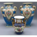C20th pair of twin handled baluster vases, sky blue ground the panels decorated with floral sprays