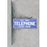 Vintage enamelled steel plate sign "You May Phone From Here" on steel scrollwork hanger. W55.8cm