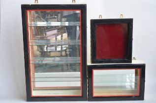 Three wall hanging front opening wood and glass display cabinets to include 2 multi-shelf examples