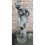 Reconstituted stone garden statue in the form of a semi-clad lady with separate circular base,