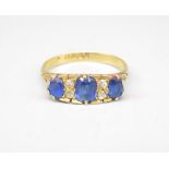 18ct yellow gold diamond and sapphire ring, with three oval cut sapphires separated by brilliant cut