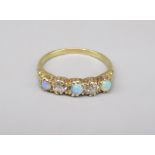 18ct yellow gold ring set with two diamonds and three opals, stamped 18ct, Size O, 3.1g