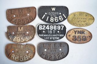 Eight cast metal railway wagon plates, (7 steel, 1 brass).