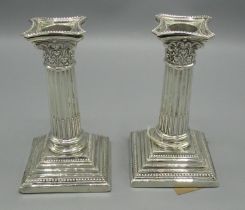 Pair of small Geo.V hallmarked silver Corinthium column candlesticks, stop fluted columns on stepped