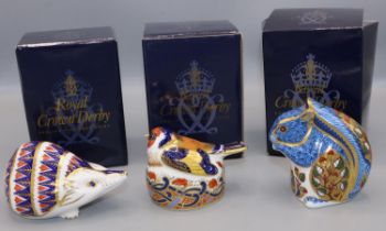 Three Royal Crown Derby paperweights: Debenhams Squirrel, Nesting Goldfinch, and Hedgehog, with