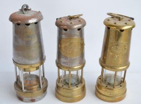 Three vintage miners safety lamps to include one by British Coal Mining Company, Wales (from