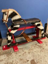 Child's hand made dapple painted rocking horse, metal swing action on open work base, W96cm H68cm