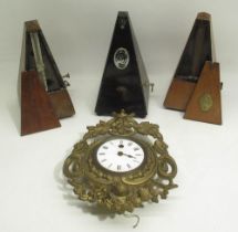 Early C20th continental cast brass wall time piece with white enamel Roman dial and three metronomes