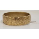 Hallmarked 9ct gold bangle, front engraved with scrolls and leaves pattern, internal width 6cm, 22.