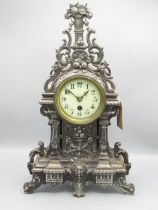 C20th French burnished steel rococo style mantle timepiece, the cast steel case decorated with